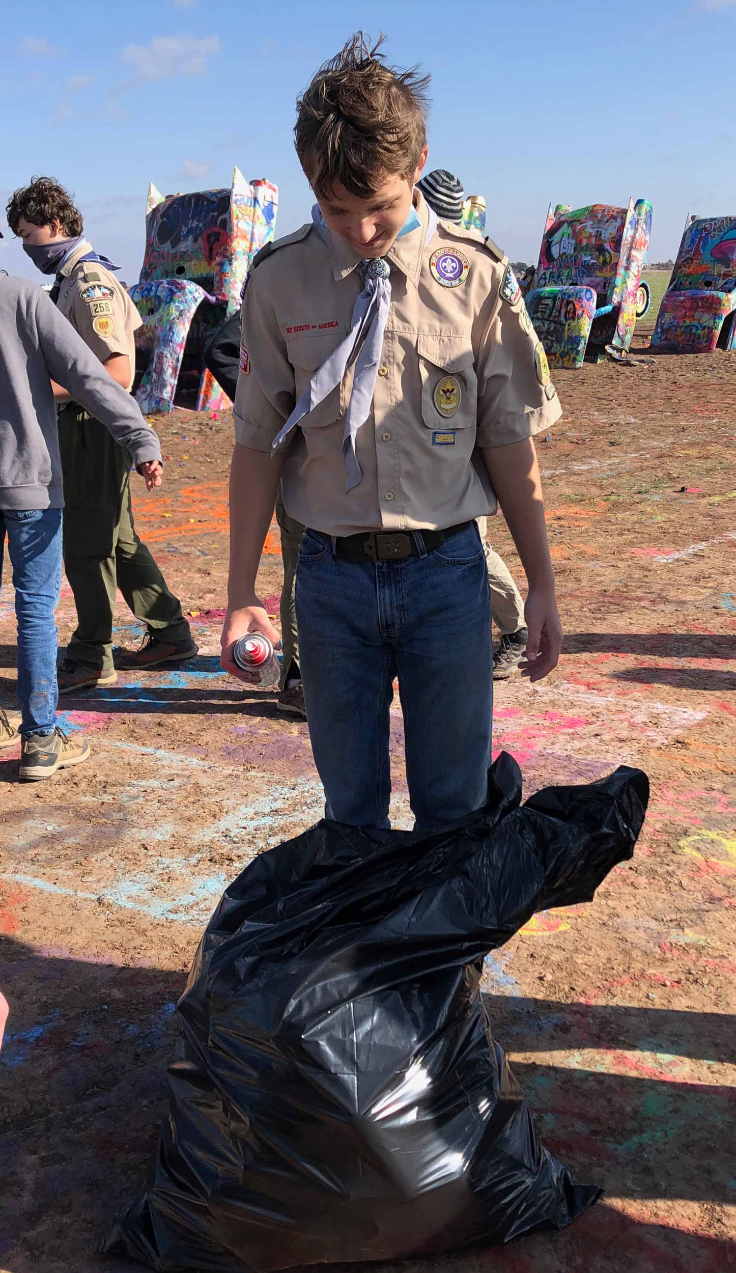 Scout with garbage bag with empty paint cans