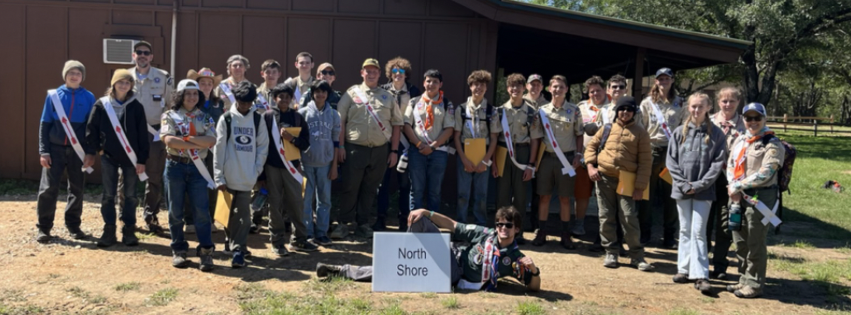 Group of scouts in front of a building at a camp